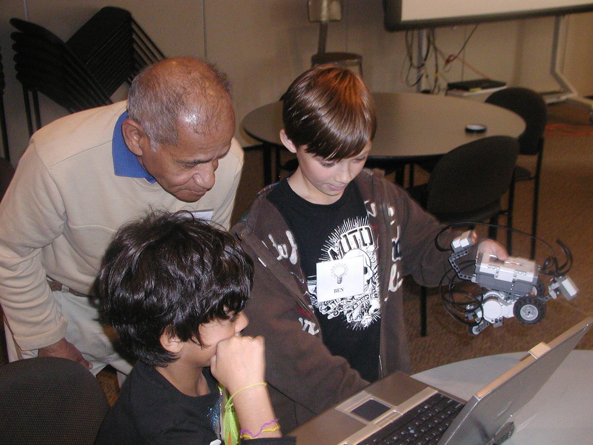Volunteer looking at a computer with children